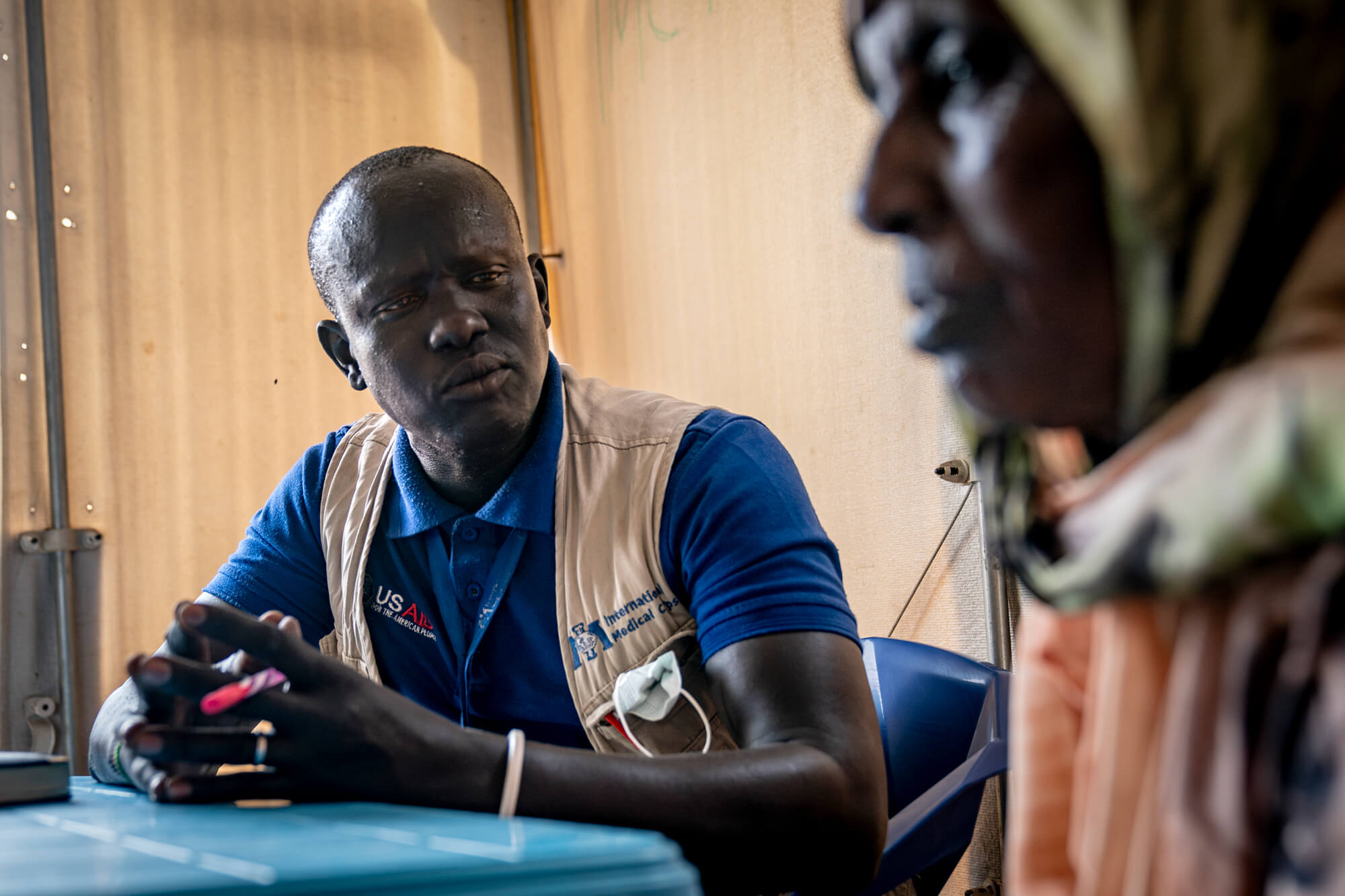 Peter Gatkoi, Mental Health Counselor, talks to a patient at the health clinic in Renk.